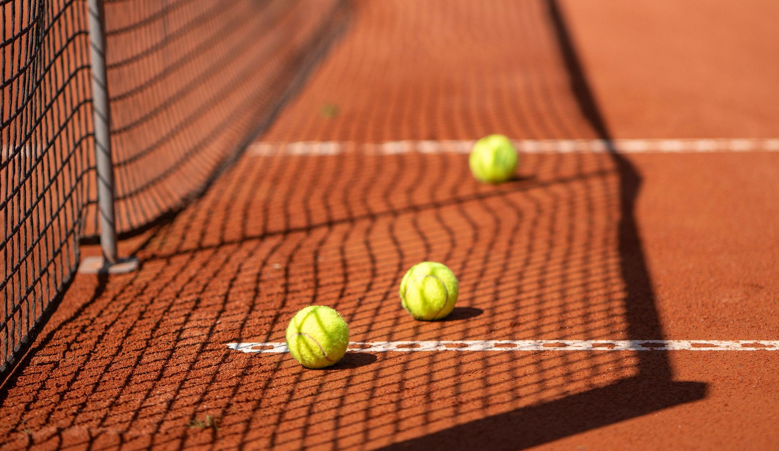 Tennisb&auml;lle auf roter Asche
